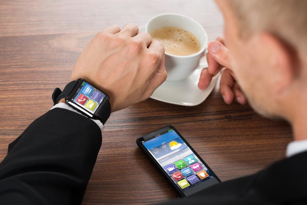 Businessman With Smartphone And Smartwatch Drinking Coffee