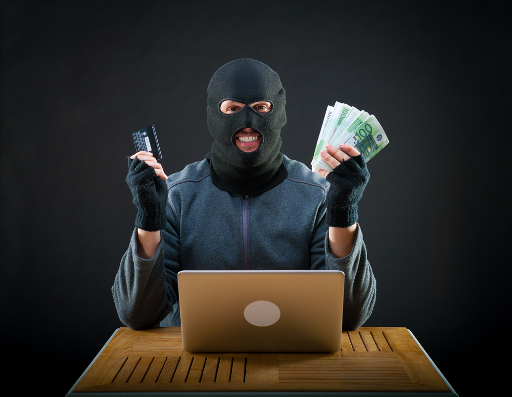 Happy cybercriminal man holding euro cash