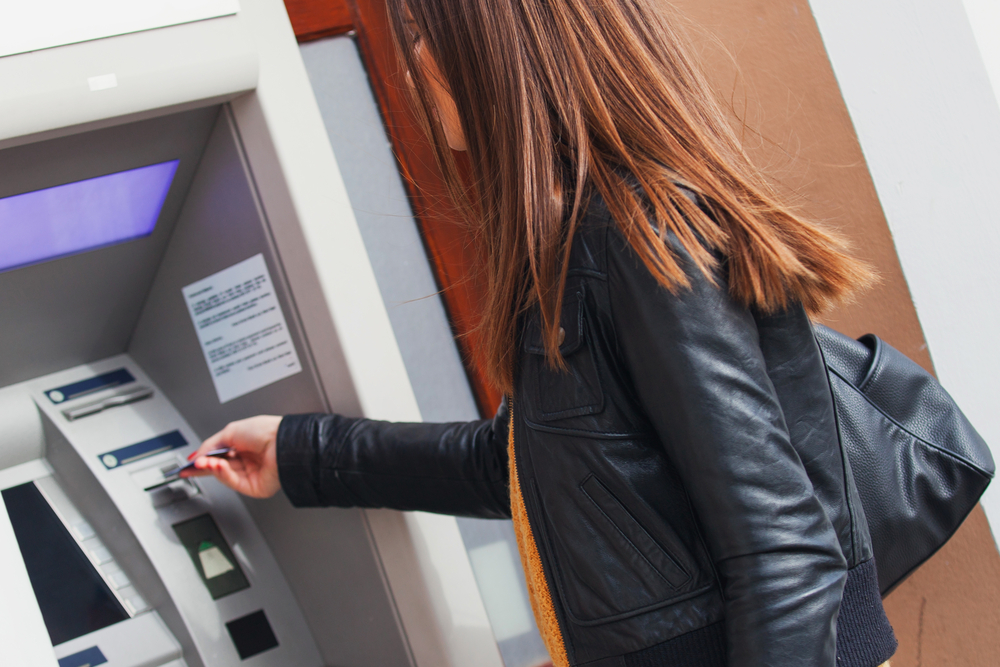 Young Woman Withdrawing Money at the Bank Machine