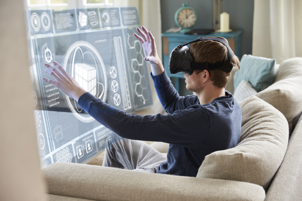 man-sitting-on-sofa-at-home-wearing-virtual-reality-headset