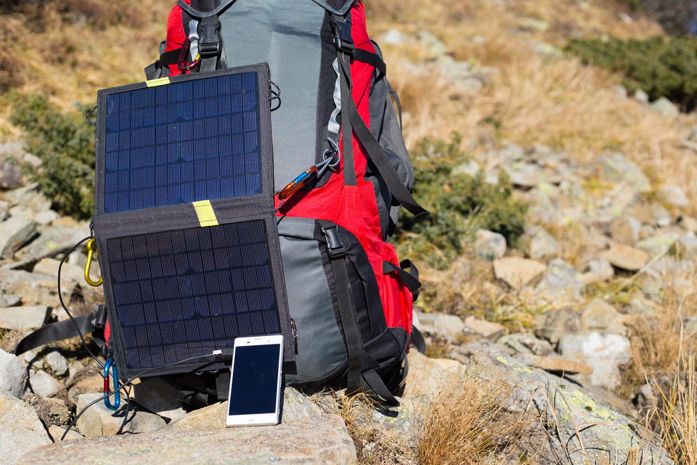 solar-panel-attached-to-the-tent-the-man-sitting-next-to-mobile-phone-charges