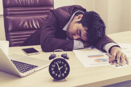 tired-businessman-sleeping-on-workdesk