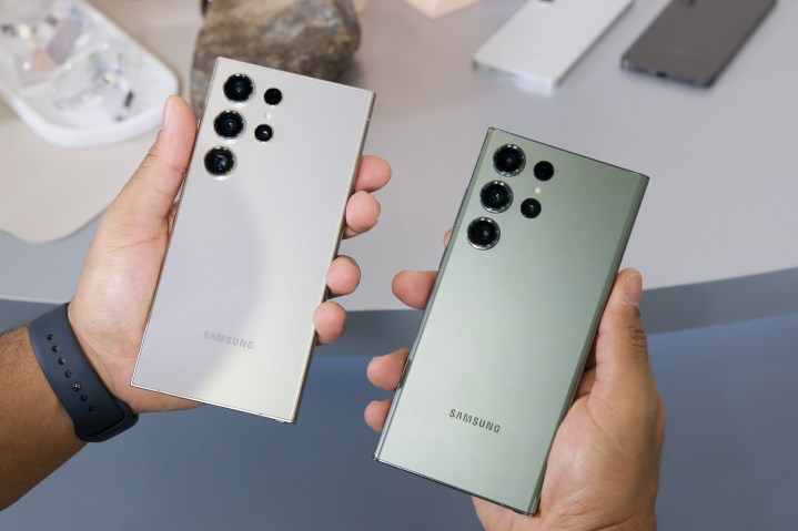Кто-то держит Samsung Galaxy S24 Ultra и Galaxy S23 Ultra.