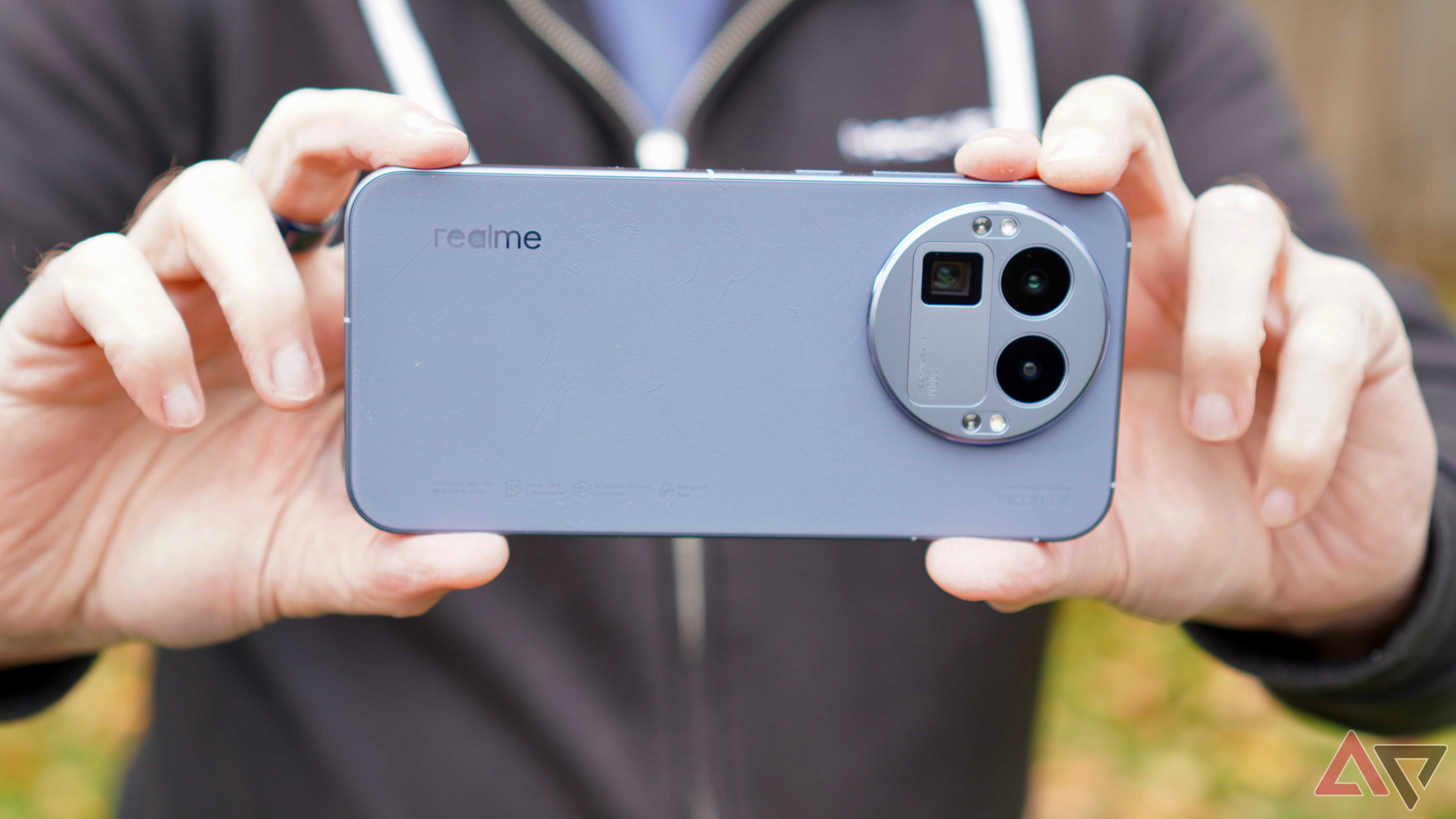 Людина тримає Realme GT 8 Pro та робить фото