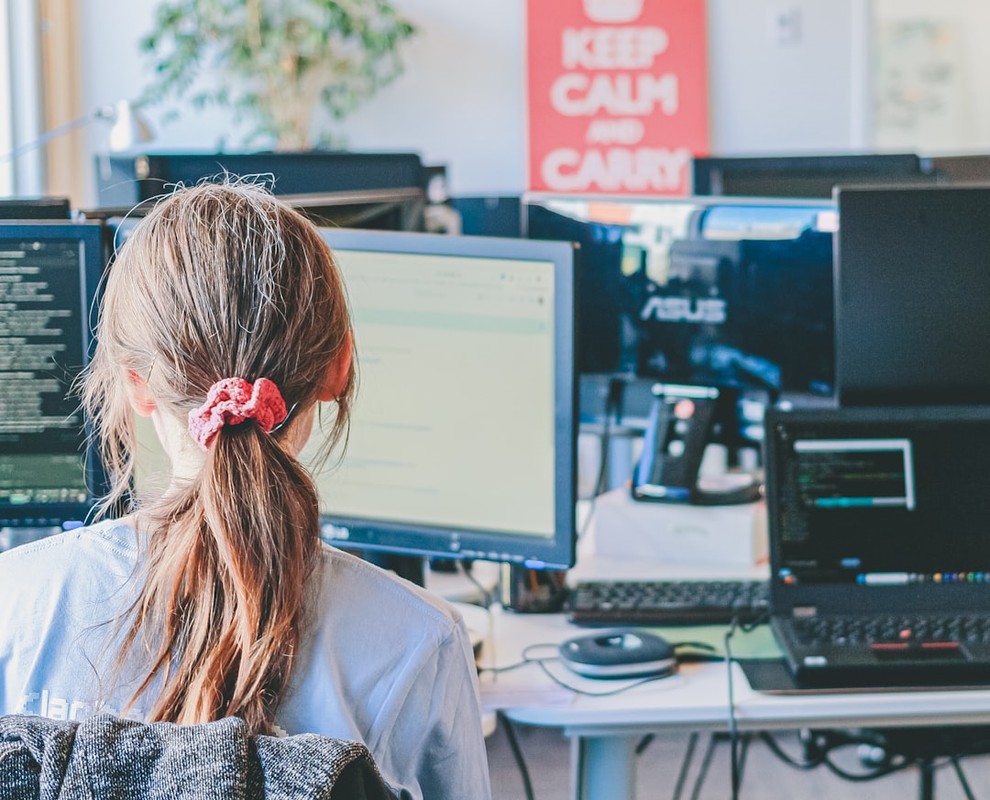 Woman working on computers in an office.