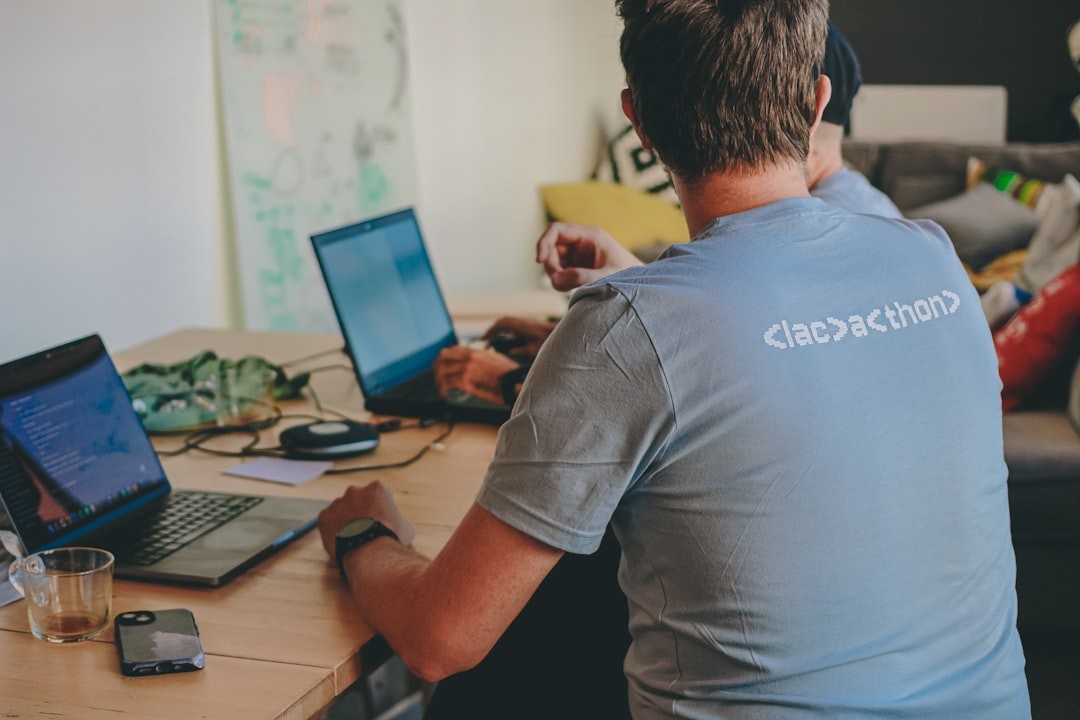 Two people working on laptops at a table.