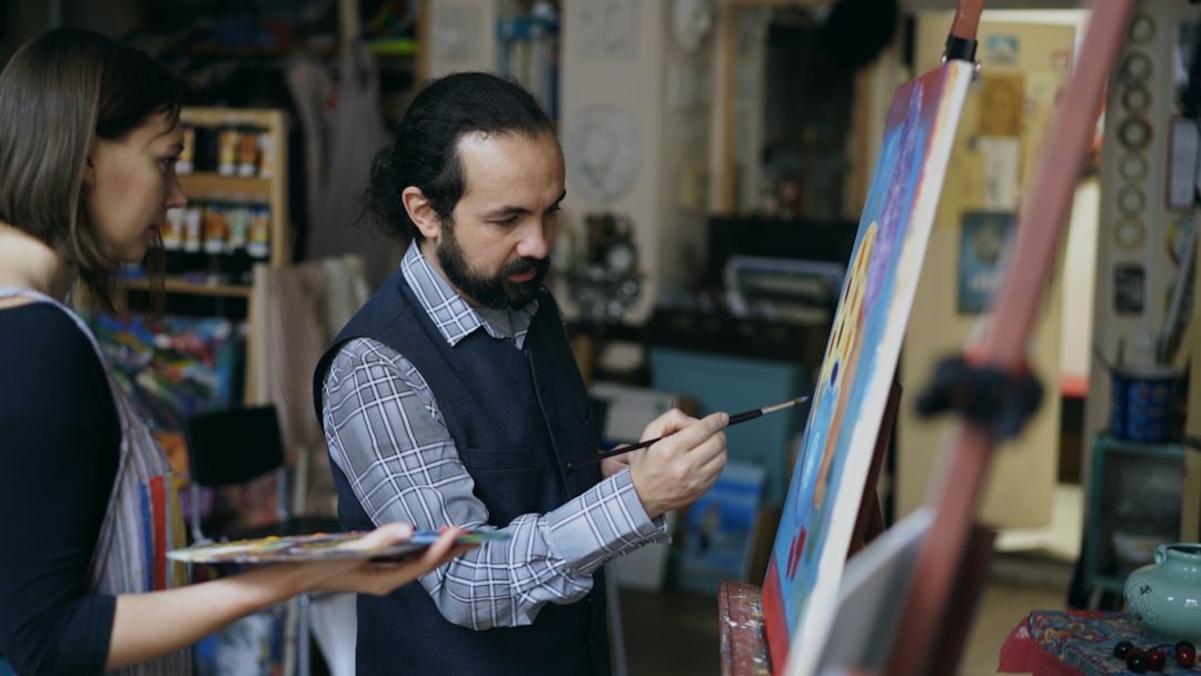 Artist and student painting together in studio