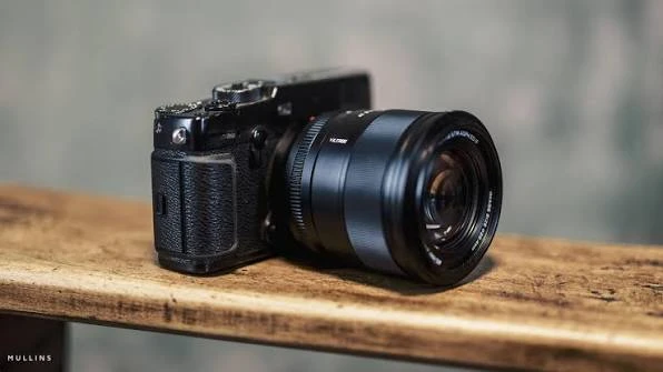 Об'єктив Viltrox AF 27mm F1.2 Pro X-Mount на далекомірній камері Fujifilm X-Pro чорного кольору на дерев'яній лаві