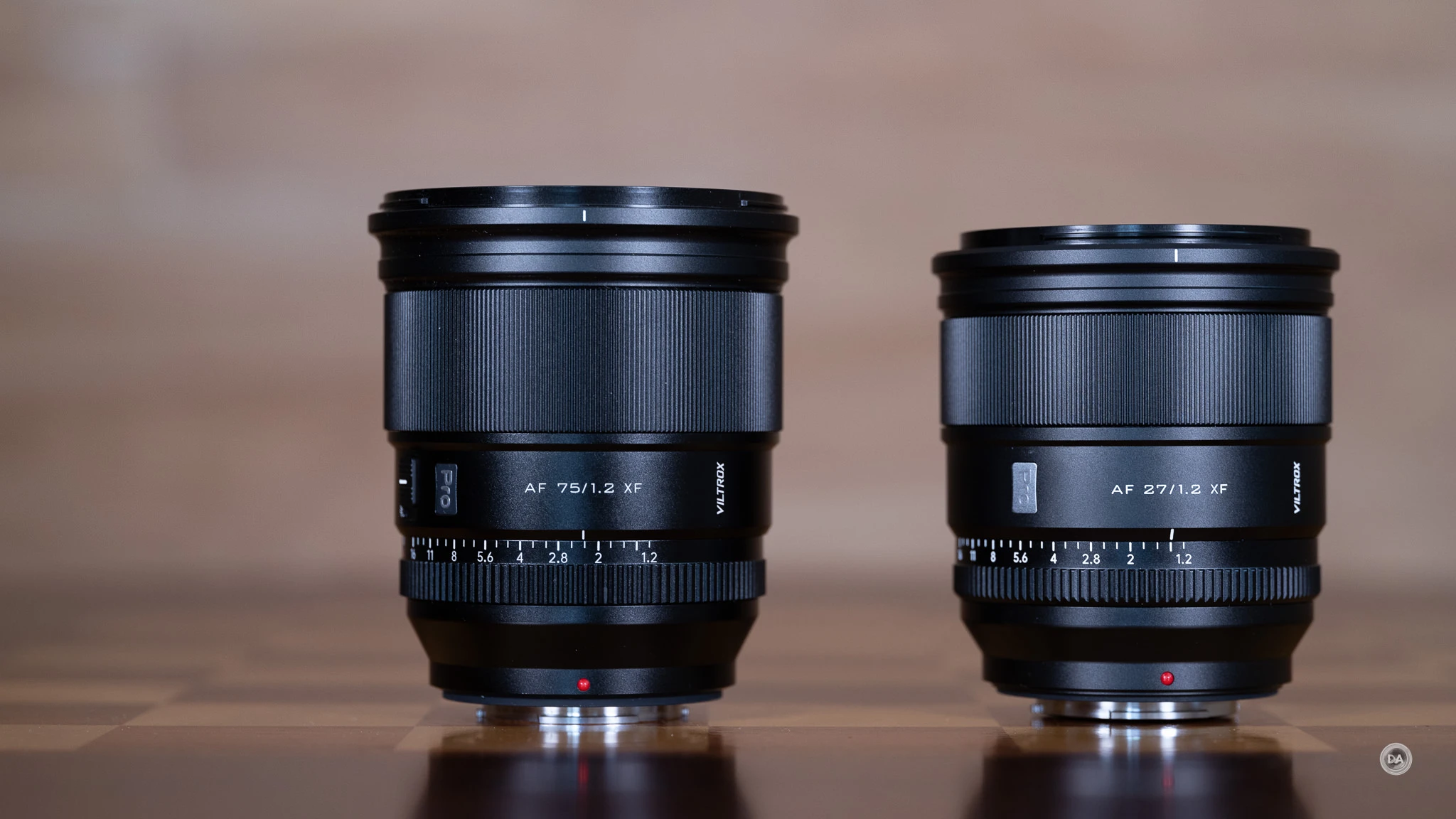 Порівняння розмірів об'єктивів лінійки Viltrox Pro для Fujifilm XF 75mm та 27mm на полірованому столі