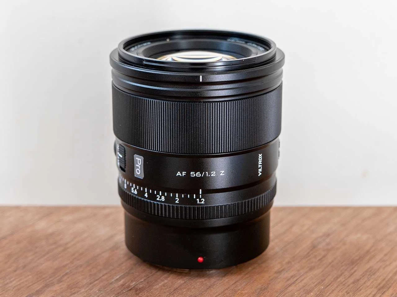 Об'єктив Viltrox AF 56mm f/1.2 Pro на столі з чітко видимим металевим байонетом, кільцем діафрагми та маркуванням лінійки Pro